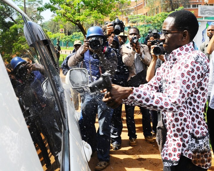 Gilbert Arinaitwe from the Elite Brigade (not formal) of the Uganda Police smashes the windscreen of Kizza Besigye's car with the butt of a pistol before arresting him on April 28, 2011